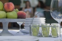 Vista close-up de mesa colocada com maçãs, pêssegos e bebidas de frutas — Fotografia de Stock