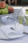 Vista close-up de mesa colocada com frutas em stand, talheres e louças — Fotografia de Stock