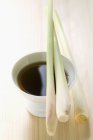 Closeup view of lemon grass on small bowl of soy sauce — Stock Photo