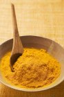 Turmeric in wooden bowl with spoon — Stock Photo