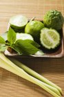 Limes with kaffir limes and Thai basil — Stock Photo