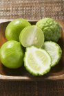 Fresh limes in wooden bowl — Stock Photo