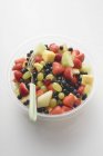 Вид крупным планом фруктового салата в пластиковой миске с вилкой — стоковое фото