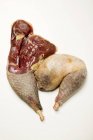 Primer plano vista superior de dos patas de gallina de Guinea cruda en la superficie blanca - foto de stock