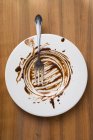 Вид зверху на тарілку з залишками шоколадного соусу — стокове фото