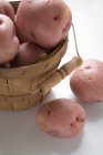 Patatas rojas en cesta de virutas de madera - foto de stock