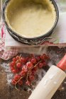 Baking tin lined with dough and redcurrants — Stock Photo