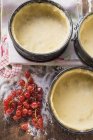 Baking tins lined with dough and redcurrants — Stock Photo