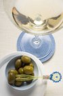 Martini y aceitunas verdes en la mesa - foto de stock