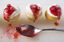 Muffins con crema y grosellas rojas - foto de stock