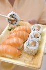 Donna che tiene sushi maki e nigiri — Foto stock
