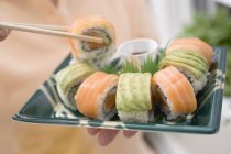 Donna che tiene sushi maki — Foto stock
