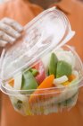 Donna con contenitore di plastica di verdure — Foto stock