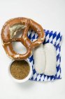 Weisswurst in packaging with pretzel — Stock Photo