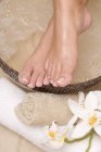 Обрізаний вид жіночих ніг над заспокійливою ванною — стокове фото