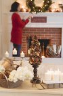 Donna con camino in soggiorno decorato per Natale — Foto stock
