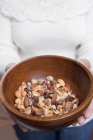 Woman holding bowl of nuts — Stock Photo