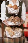 Vue recadrée d'une femme tenant un stand à plusieurs niveaux de produits de boulangerie — Photo de stock