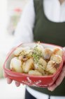 Woman holding glazed onions in Christmassy bowl, close-up view — Stock Photo