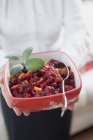 Primo piano vista ritagliata della donna che tiene piatto di salsa di mirtilli rossi — Foto stock