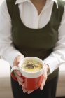 Mulher segurando xícara de molho de cogumelos — Fotografia de Stock