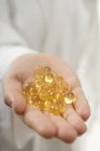 Vista close-up de mão segurando cápsulas de vitamina — Fotografia de Stock