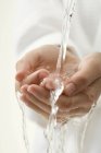 Geschälte weibliche Hände unter fließendem Wasser — Stockfoto
