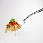 Спагетти с томатным соусом на вилке — стоковое фото