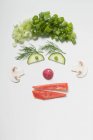Cara divertida hecha de verduras, eneldo y setas sobre fondo blanco - foto de stock