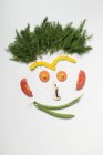 Amusing face made from vegetables, rosemary and mushroom on white surface — Stock Photo