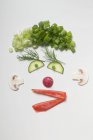 Amusing face made from vegetables, dill and mushrooms over white surface — Stock Photo