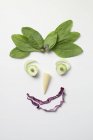 Gemüsegesicht mit Spinathaaren auf weißem Hintergrund — Stockfoto