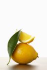 Свежий лимон с ломтиком и листом — стоковое фото