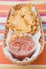 Nachos and salsa in basket — Stock Photo