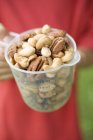 Human hands holding jug  of nuts — Stock Photo