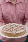 Cropped view of woman holding Linzer torte — Stock Photo