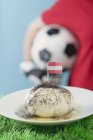 Closeup view of yeast dumpling with flag and footballer on background — Stock Photo