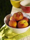 Schüssel Pfirsiche auf Handtuch — Stockfoto