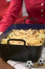 Frau serviert Käse Pasta backen — Stockfoto