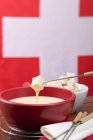 Cheese fondue in front of flag — Stock Photo