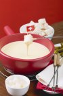 Cheese fondue with Swiss flag — Stock Photo