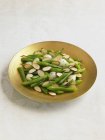 Green Beans with Slivered Almonds and Onions on yellow plate  on white background — Stock Photo