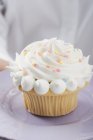 Frauenhände halten Cupcake auf Teller — Stockfoto