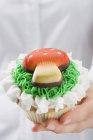 Mani che tengono cupcake con agarico mosca marzapane — Foto stock