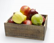 Manzanas surtidas en caja de madera - foto de stock