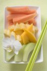 Sliced exotic fruits and orchid — Stock Photo