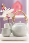 Bule, tigela de chá e orquídea — Fotografia de Stock