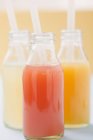 Three fruit juices in bottles — Stock Photo