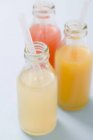Três sucos de frutas em garrafas — Fotografia de Stock