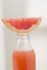 Pink grapefruit juice in bottle — Stock Photo